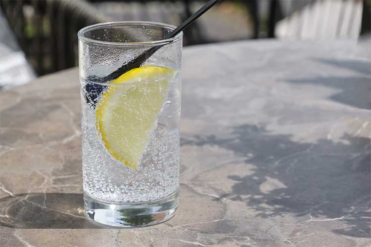 glass of sparkling water with a slice of lemon